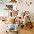 Collection of colourful Moroccan boho cushion covers arranged on a floor and sofa