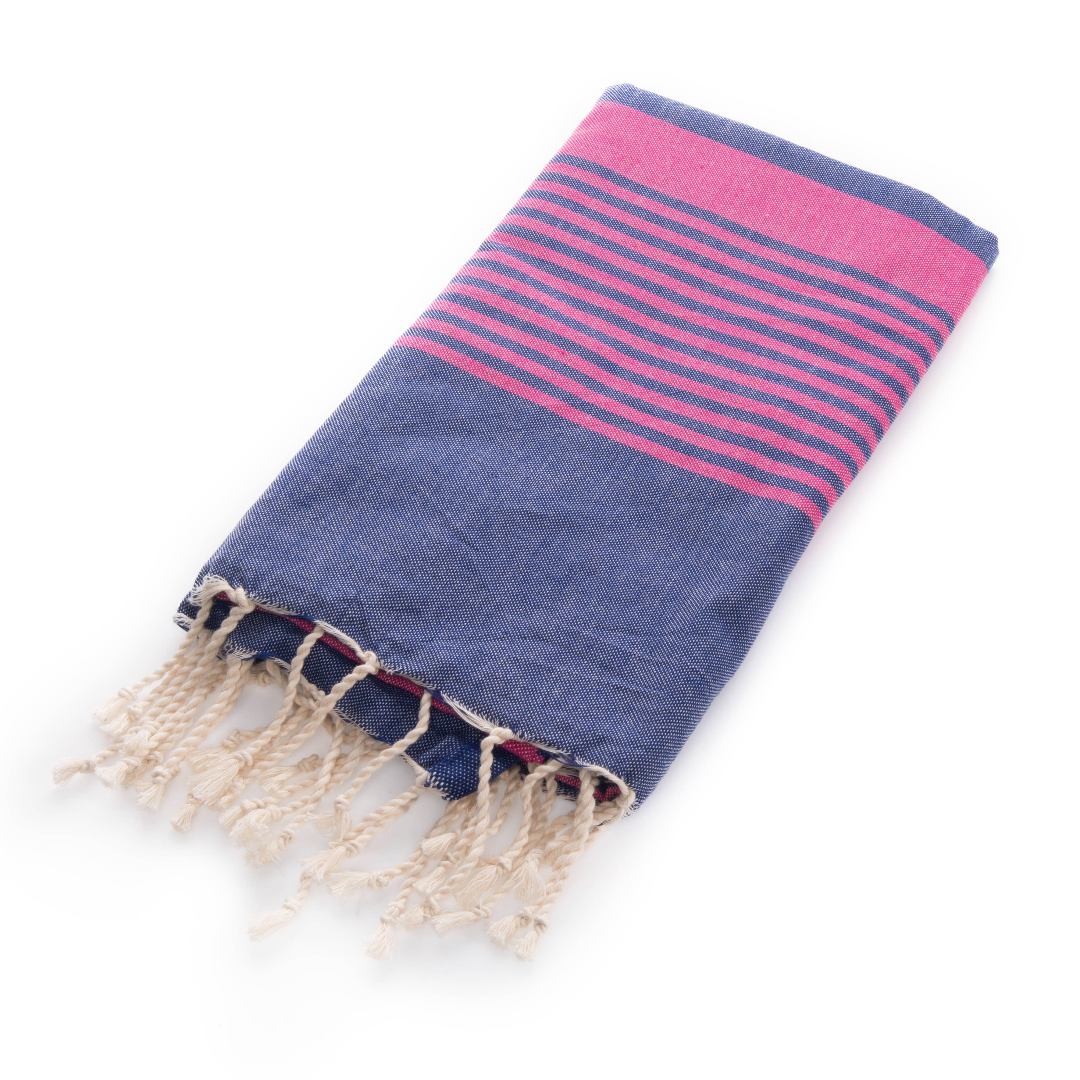 Folded Miami Beach Fouta Turkish towel in navy blue with vibrant fuchsia stripes and tassels