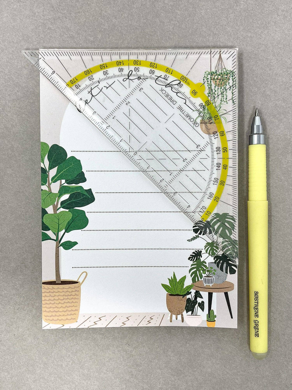 Home A6 notepad displayed with yellow pen and clear ruler