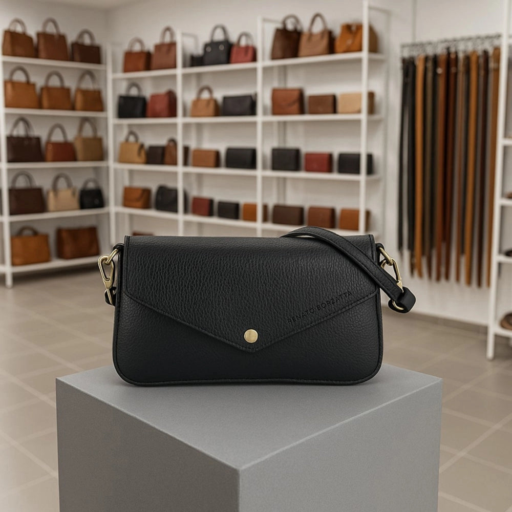Black leather shoulder bag displayed on a grey pedestal in a boutique setting